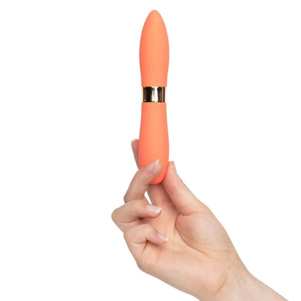 Orange and gold sex toy in hand.