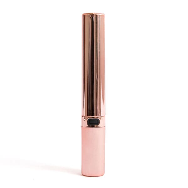 Rose gold lipstick tube on white background.