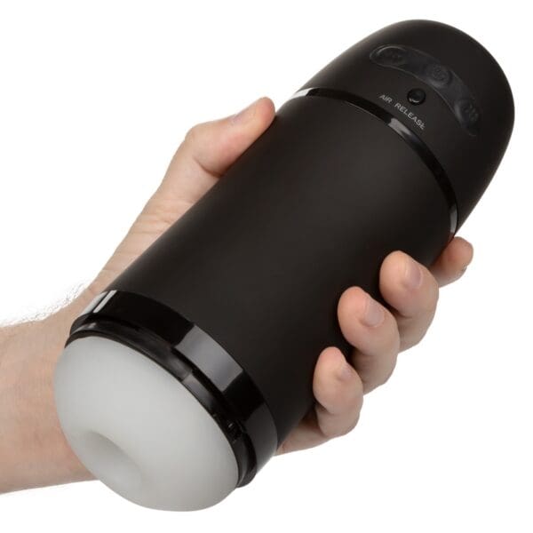 A hand holding a black bottle with a white light.