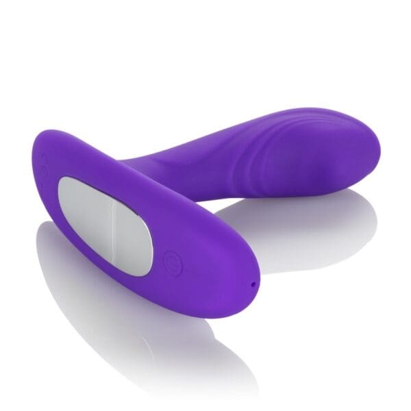 A purple vibrator is laying on the ground.