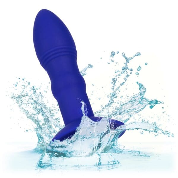 A blue sex toy is splashing in water.