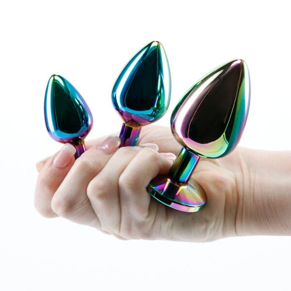 Three iridescent anal plugs in hand.